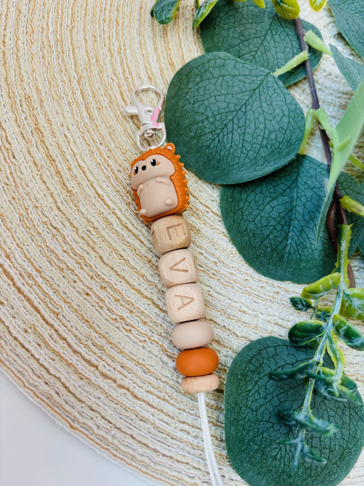 Handgemaakte sleutelhanger met naam naar keuze. Met een siliconen 3D egeltje in herfst oranje, naam in beukenhouten letters.