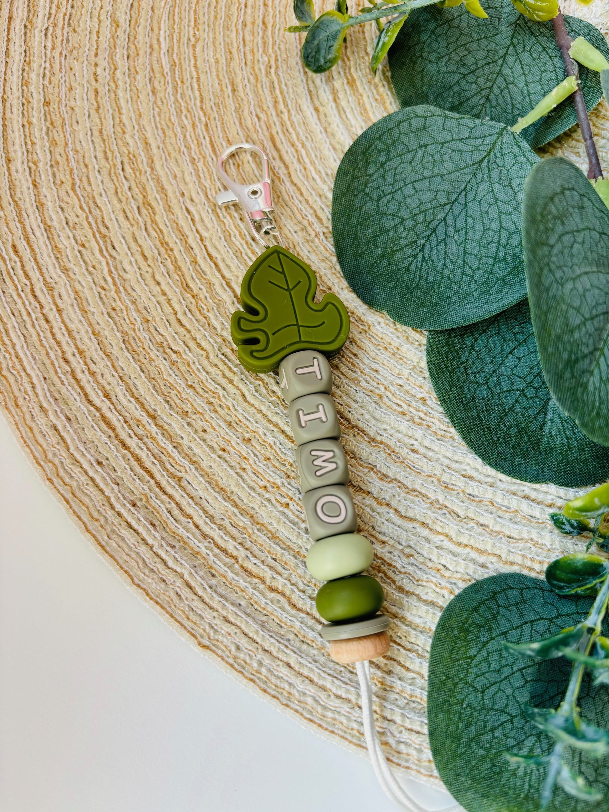 Handgemaakte sleutelhanger met naam naar keuze. Met een siliconen Monstera blad in olijfkleur, naam in groene letters.