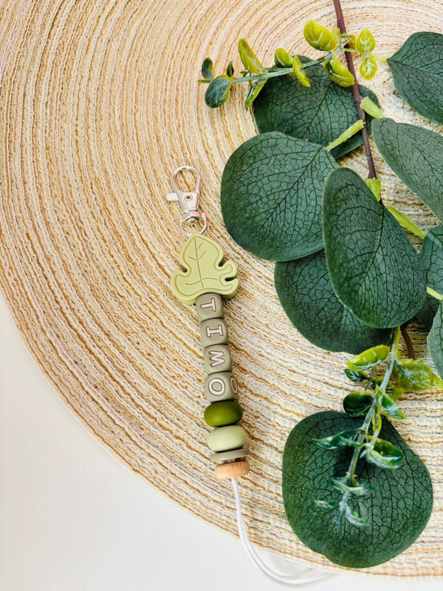 Handgemaakte sleutelhanger met naam naar keuze. Met een siliconen Monstera blad in zacht groene kleur, naam in groene letters.