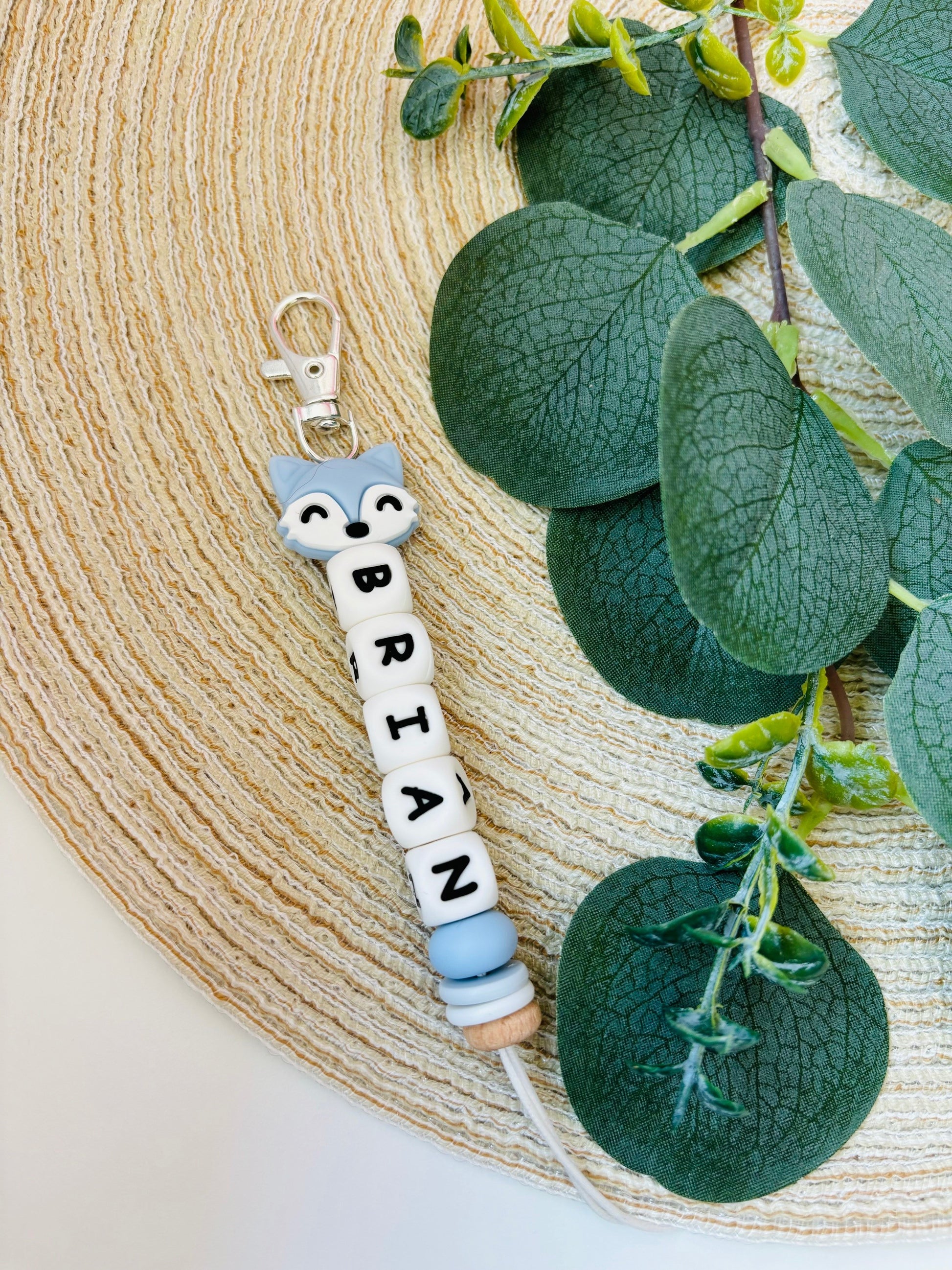 Handgemaakte sleutelhanger met naam naar keuze. Met een siliconen vossenhoofdje in zacht blauw, naam in witte letters.